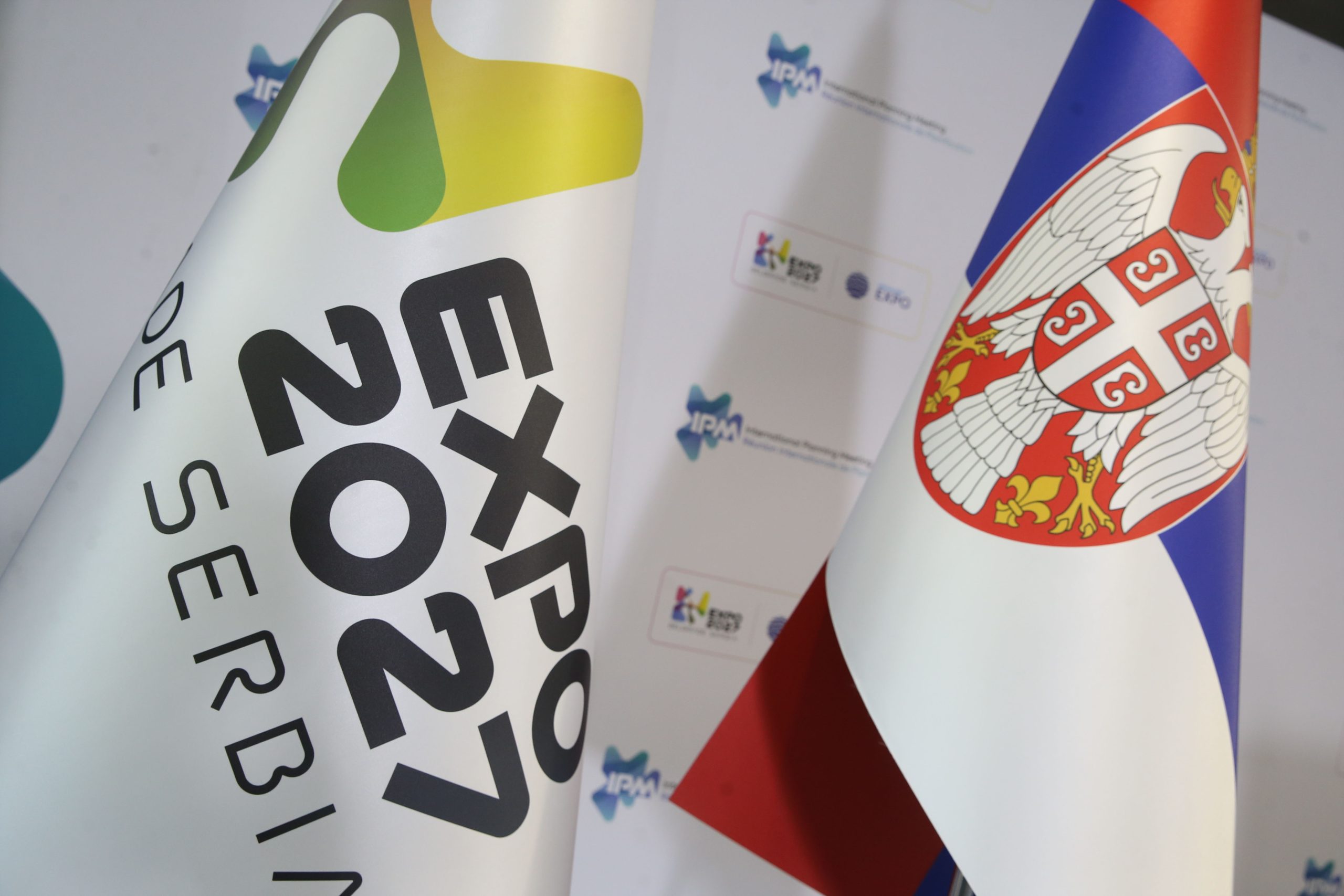 Застава специјализоване светске изложбе Експо 2027 (лево) која ће бити одржана у Београду и застава Републике Србије