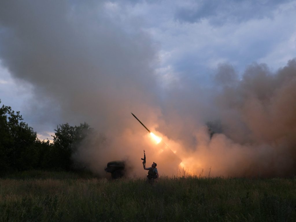 Украјински војник реагује док његови саборци испаљују ракете из система БМ-21 Град према руским трупама
